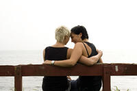 Women sitting on a bench hugging